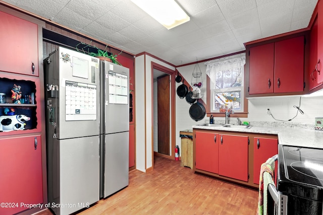 kitchen featuring stainless steel fridge, sink, stove, and light hardwood / wood-style flooring