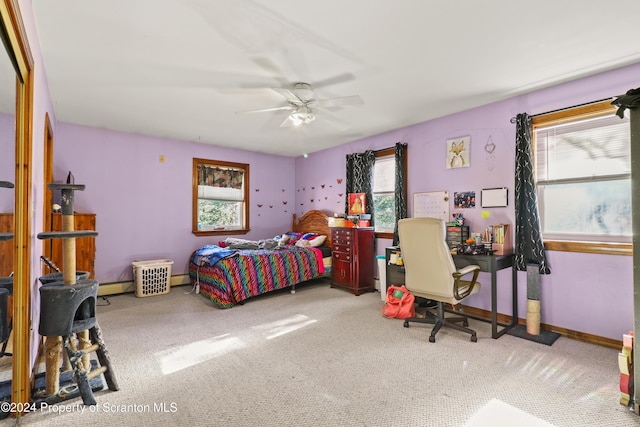 carpeted bedroom with ceiling fan and a baseboard radiator