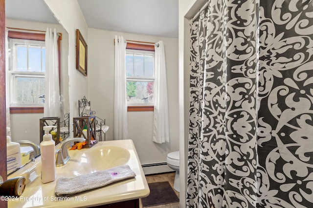 bathroom featuring baseboard heating, vanity, and toilet