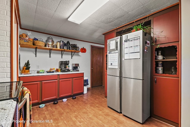 kitchen with light wood-type flooring, stainless steel appliances, and crown molding