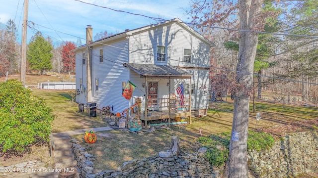 view of front facade featuring a wooden deck and a front lawn