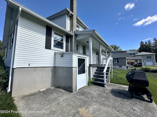 1402 Cherry St, Scranton, PA 18505 - view of home's exterior featuring a chimney, covered porch, and a lawn