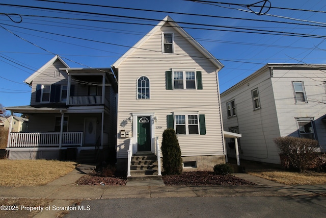 traditional-style house with covered porch and a balcony