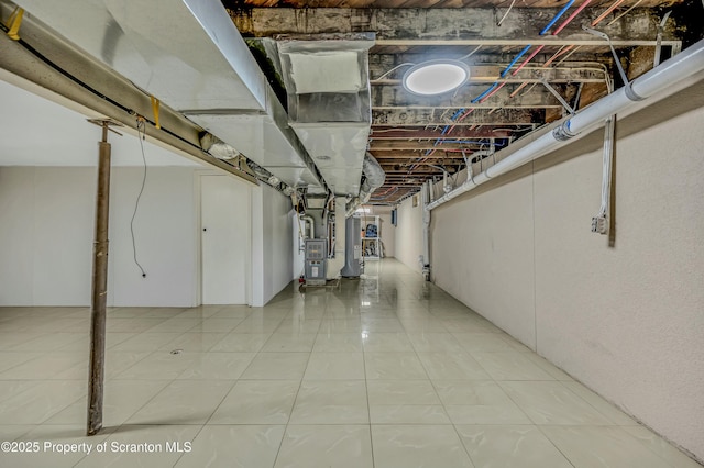 unfinished basement featuring light tile patterned flooring, heating unit, and water heater