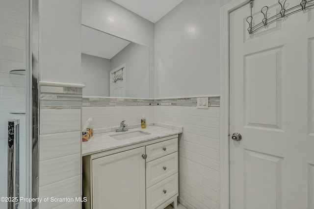 bathroom featuring vanity and tile walls