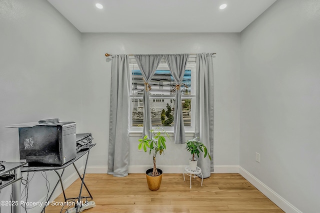 interior space with baseboards, light wood-style flooring, and recessed lighting