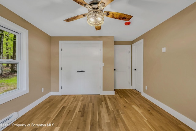 40 Honey Bear Rd, Lake Ariel, PA 18436 - unfurnished bedroom featuring baseboard heating, baseboards, light wood-style flooring, and a closet