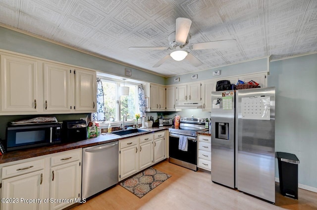 kitchen with ceiling fan, light wood-type flooring, sink, and stainless steel appliances