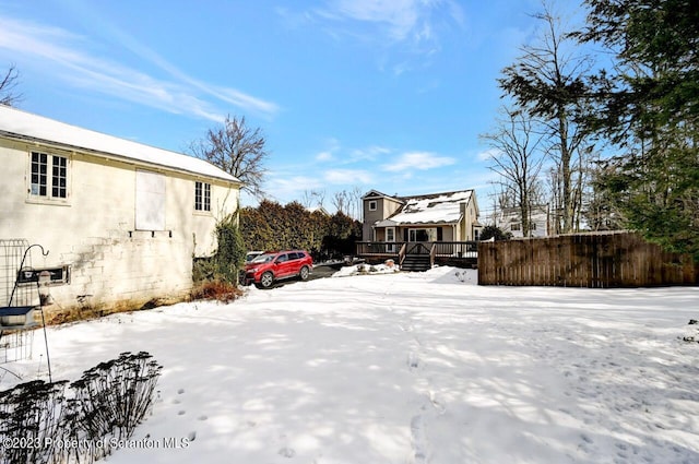 yard covered in snow with a wooden deck