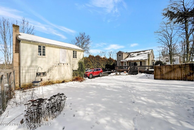 view of snowy exterior with a deck