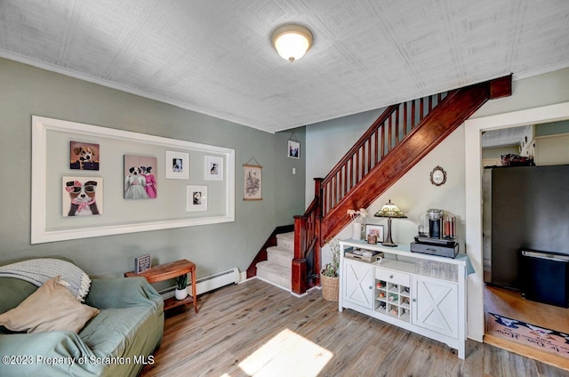 stairs featuring hardwood / wood-style floors and baseboard heating