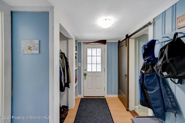 mudroom featuring a barn door and light wood-type flooring