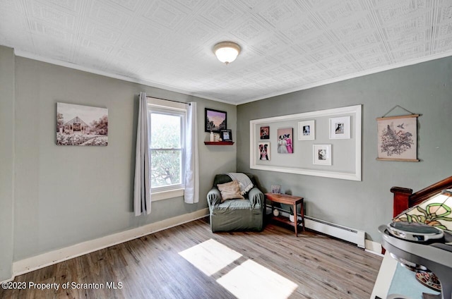 sitting room with light hardwood / wood-style flooring and a baseboard heating unit