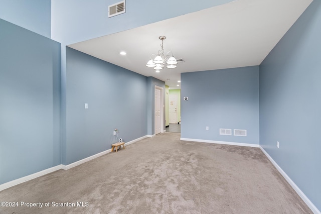 empty room with carpet and a chandelier