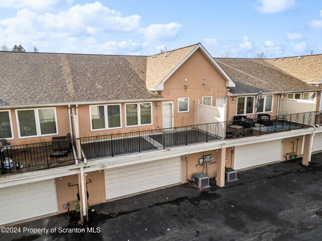 rear view of house with cooling unit and a garage