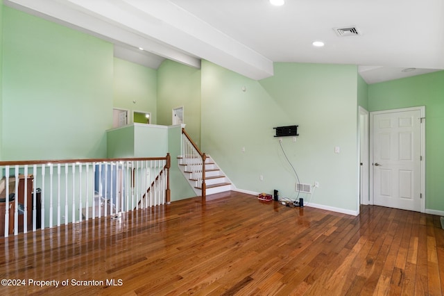 spare room featuring hardwood / wood-style flooring and vaulted ceiling