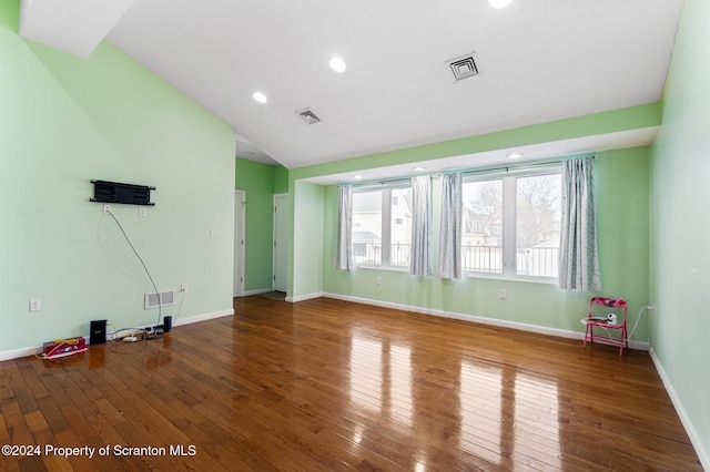 empty room featuring wood-type flooring and lofted ceiling