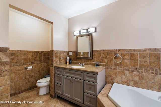 bathroom with a tub to relax in, vanity, tile walls, tile patterned flooring, and toilet