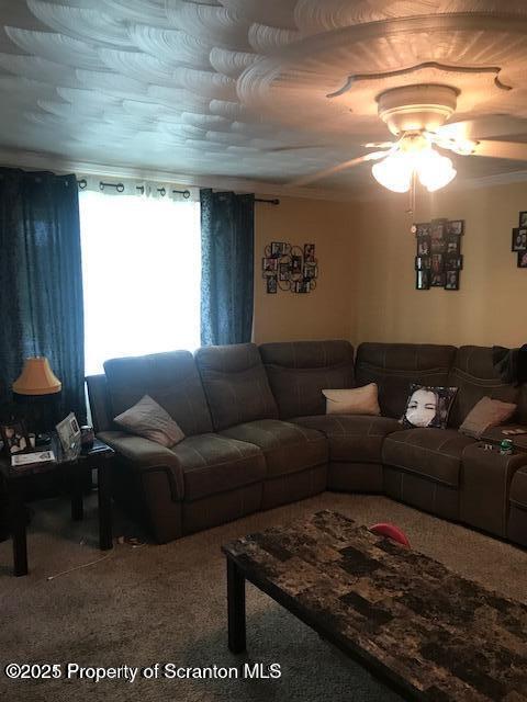 203 E Jefferson St, Olyphant, PA 18447 - carpeted living area with a ceiling fan