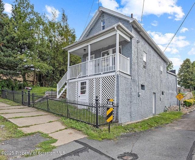 view of side of property with a yard and covered porch