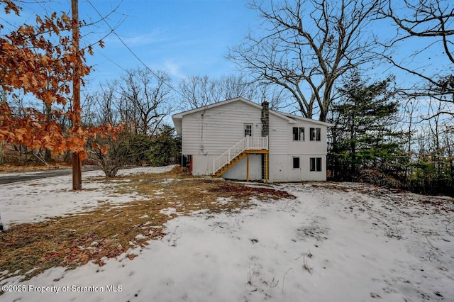 view of snow covered rear of property