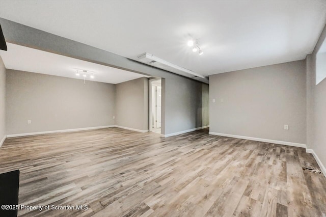 basement with track lighting and light wood-type flooring