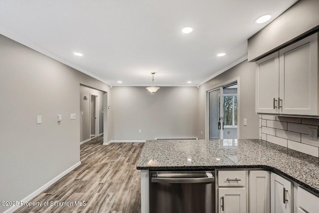 kitchen with white cabinets, pendant lighting, stainless steel dishwasher, and dark stone countertops