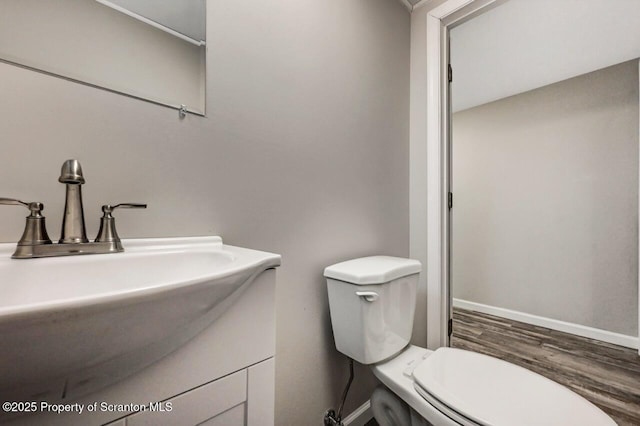 bathroom featuring toilet, wood-type flooring, and sink