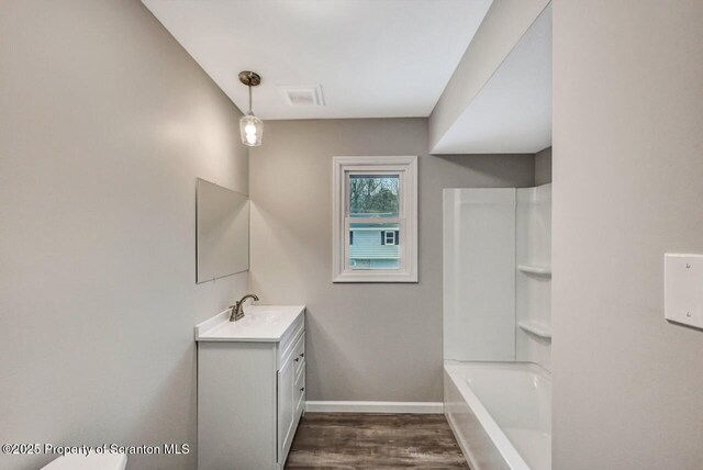 bathroom featuring hardwood / wood-style floors, vanity, and bathing tub / shower combination