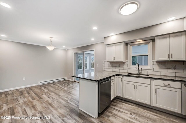 kitchen with kitchen peninsula, stainless steel dishwasher, baseboard heating, sink, and white cabinets