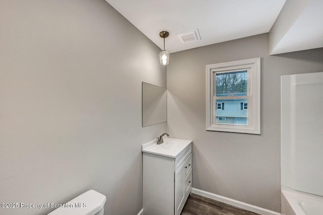 bathroom with hardwood / wood-style floors, vanity, and toilet