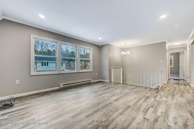 spare room with light wood-type flooring, an inviting chandelier, crown molding, and a baseboard heating unit