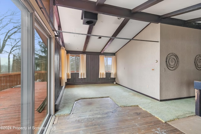 unfurnished sunroom featuring beamed ceiling and a baseboard radiator