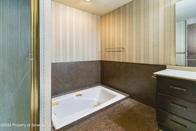 bathroom featuring vanity and tiled tub