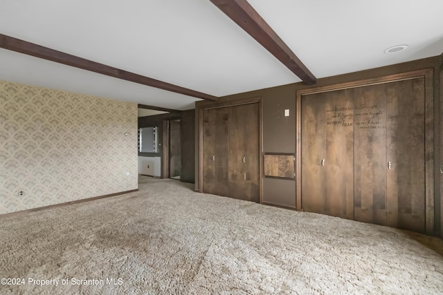 interior space featuring carpet and beamed ceiling