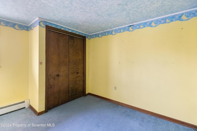 unfurnished bedroom featuring light carpet, a textured ceiling, a baseboard radiator, and a closet