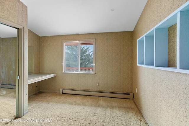 unfurnished bedroom featuring carpet flooring and a baseboard heating unit