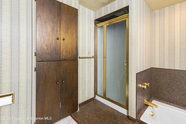 bathroom featuring separate shower and tub