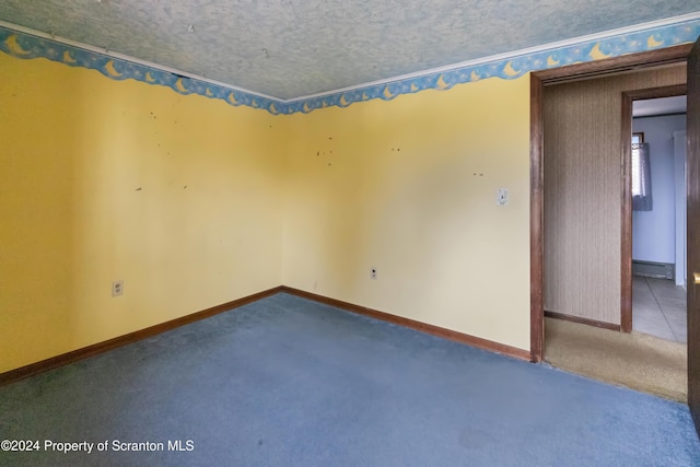 unfurnished room featuring carpet flooring, a textured ceiling, and a baseboard heating unit