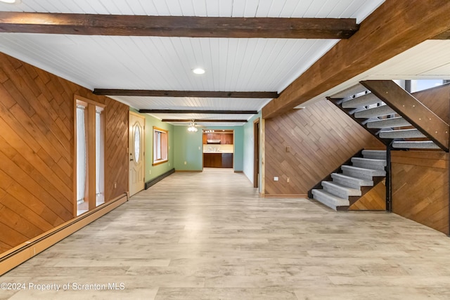 interior space with beamed ceiling, wood walls, baseboard heating, and hardwood / wood-style floors