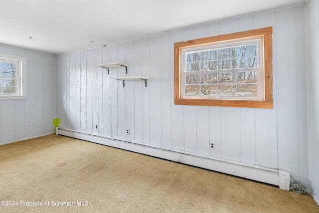 carpeted spare room featuring a wealth of natural light and a baseboard radiator