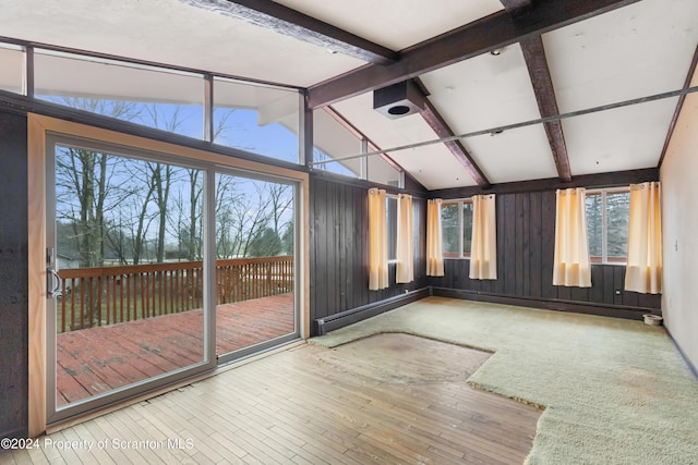 unfurnished sunroom featuring lofted ceiling with beams and a healthy amount of sunlight