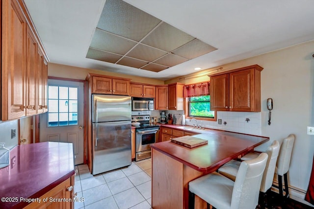 226 Linda Ln, Scranton, PA 18504 - kitchen with stainless steel appliances, brown cabinetry, light tile patterned floors, and tasteful backsplash