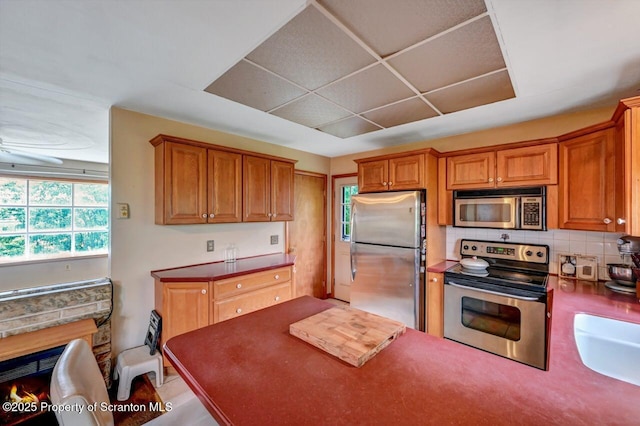 226 Linda Ln, Scranton, PA 18504 - kitchen featuring appliances with stainless steel finishes, backsplash, brown cabinets, and dark countertops