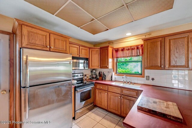 226 Linda Ln, Scranton, PA 18504 - kitchen with stainless steel appliances, backsplash, brown cabinetry, light tile patterned floors, and recessed lighting