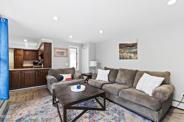 living room featuring a baseboard heating unit and light wood-type flooring