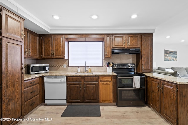 kitchen featuring sink, light hardwood / wood-style flooring, dishwasher, ventilation hood, and range with two ovens