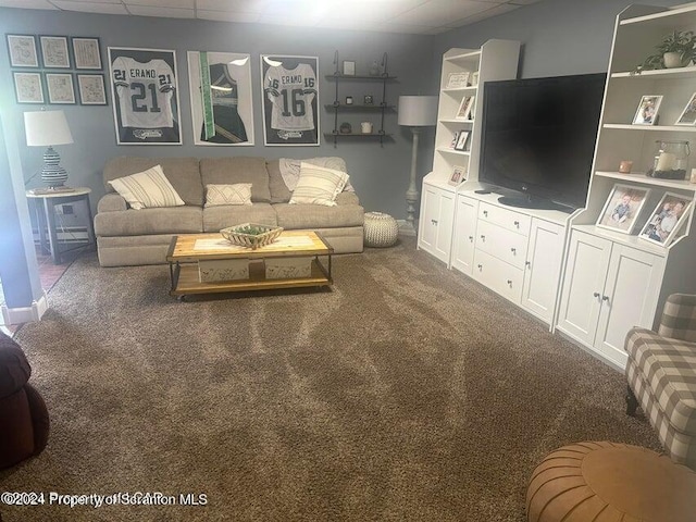 living room featuring carpet and a paneled ceiling