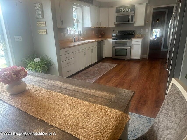 kitchen featuring dark wood-type flooring, white cabinetry, sink, and stainless steel appliances