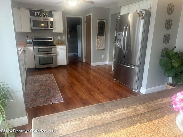 kitchen with dark hardwood / wood-style flooring, stainless steel appliances, white cabinetry, and ceiling fan